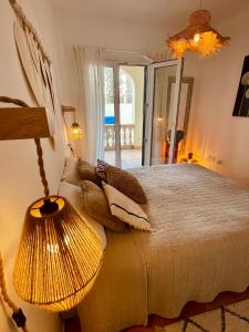 卡拉菲格拉Can Somni - Appartement bohème, zen et chic avec piscine的一间卧室配有一张带灯和镜子的床
