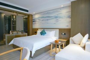 广州Paco Hotel Tiyuxilu Metro Guangzhou- 1 minute walk from the subway的酒店客房,配有床和沙发