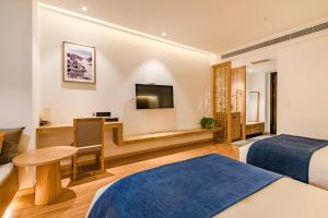 郑州素朴酒店(郑州CBD国际会展中心店)的酒店客房配有两张床和一张书桌
