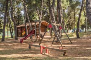 萨武德里亚Rooms Savudrija Plava Laguna的公园设有带滑梯和树木的游乐场