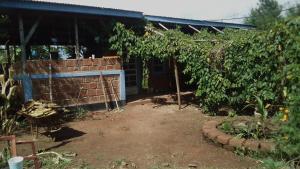 Weru WeruKimashuku permaculture garden的砖墙和花园的房子