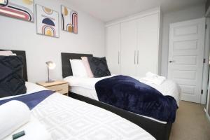 RogerstoneFree Wifi | Parking Access | 3BR的一间卧室设有两张床和一扇门