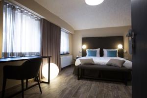 卢布尔雅那可可旅馆的一间卧室配有一张带蓝色枕头的床和一张书桌