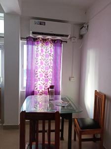 布莱尔港Punjab Residency的一张餐桌,配有紫色窗帘的窗户