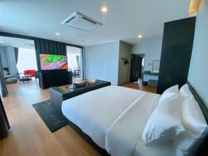 沙湾拿吉BB hotel Savannakhet的一间带白色大床的卧室和一间客厅