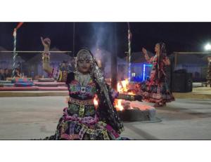 山姆Dynamic Desert Camp, Kanoi, Jaisalmer的两个女人在马戏团的火边跳舞