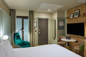伦敦master St. Paul's的酒店客房带一张床、椅子和电视