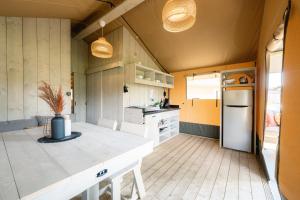 索尔陶Glampingzelt Family - Lodge的厨房设有黄色的墙壁和白色的冰箱。