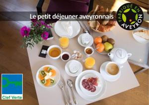 罗德兹HÔTEL LA FERME DE BOURRAN - écoresponsable parking gratuit的一张桌子,上面有早餐食品和饮料