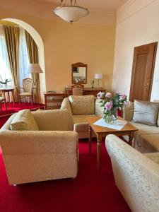 乌赫尔堡施朗斯酒店的客厅配有沙发和鲜花桌