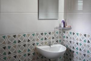 PonnampetCoorg Stream Side Homestay的一间带水槽和瓷砖墙的浴室