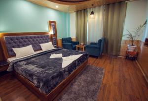 马拉里The Forest Pinnacle & Café, Manali的一间卧室配有一张大床和两把椅子