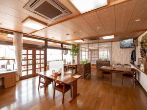 笛吹市Tabist Hotel Sun Plaza Fuefuki Isawa的大型客房配有木桌和椅子。