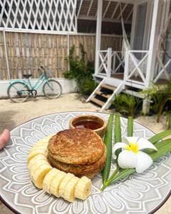 吉利特拉旺安Love Coconut Bungalow的上面有三明治和香蕉的盘子