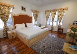 斯利那加Moustache Srinagar的一间卧室设有一张大床和两个窗户。