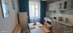乌斯季卡缅诺戈尔斯克Lux Home на берегу Ульбы的一间带桌子和冰箱的小厨房
