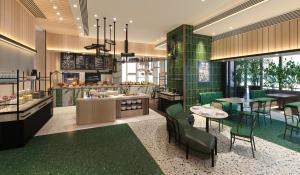 珠海珠海横琴雅辰悦居酒店的一间拥有绿色瓷砖和桌椅的餐厅