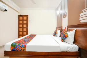 艾哈迈达巴德FabHotel Shanti Sadan Near Ellisbridge的卧室配有白色的床和木制床头板