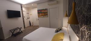 米兰马尔科纳24公寓式酒店的一间设有白色床和电视的客房
