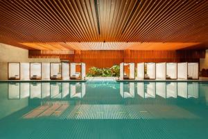 上海上海宝格丽酒店的大楼内带椅子的游泳池
