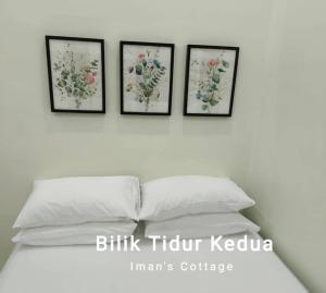 居林Iman’s Cottage Hospital Kulim Hitech的床上方墙上有三幅花框图