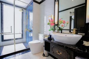 下龙湾Lotus D'Orient Cruise的一间带水槽、卫生间和镜子的浴室