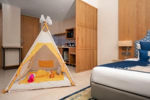 坎多林The Astor - All Suites Hotel Candolim Goa的一间卧室,配有带玩具的游戏帐篷