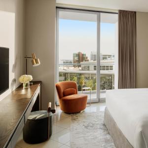 迪拜迪拜节日城洲际公寓套房酒店 的一间卧室配有一张床、一把椅子和一个大窗户