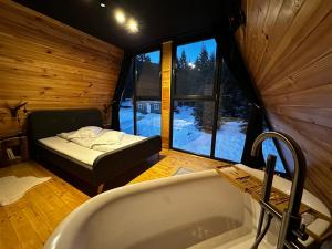沃尔托普Black Chalet的一间带浴缸的浴室和一张位于客房内的床