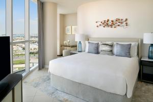 迪拜迪拜节日城洲际公寓套房酒店 的卧室设有一张白色大床和大窗户