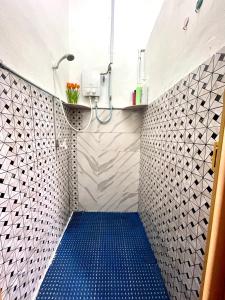 大山脚Cozy 255 Entire 3 Bedroom House At Alma Bukit Mertajam的浴室设有蓝色地板淋浴