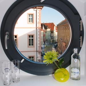 科尔马Hôtel Quatorze的桌子上的镜子,带玻璃杯和窗户