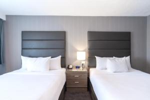 埃德蒙顿桑德曼埃德蒙顿西酒店的配有白色枕头的酒店客房内的两张床
