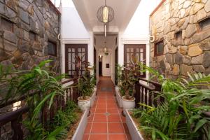 会安Hoianese Heritage Hotel - Truly Hoi An的走廊上种植了植物,设有石墙