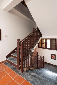 会安Hoianese Heritage Hotel - Truly Hoi An的白色墙壁的房间内的木楼梯
