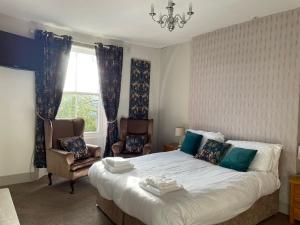 罗斯伯里土耳其头罗斯伯里宾馆的卧室配有床、椅子和窗户。