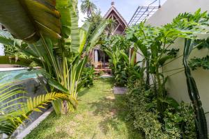 金巴兰Karma House Ungasan的一座种植了树木和植物的别墅外的花园