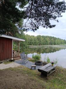 奥卢Old Finnish lakeside cottage with sauna的湖畔小屋,配有桌子和长凳