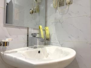 泰布克Landmark Hotel Suites的浴室设有白色水槽和镜子
