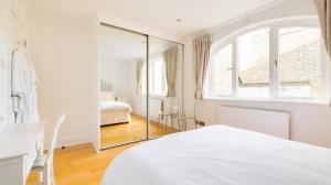伦敦Notting Hill Luxury Duplex的白色卧室配有镜子和床
