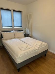 汉堡Apartmenthaus Hamburg Les Jardins的卧室设有一张大床,设有两个窗户