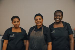 GobabisAfrica Awaits Lodge & Safaris的三个女人站在厨房里