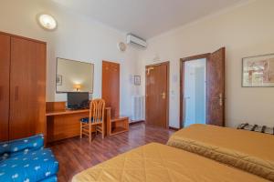 罗马Hotel Monte Verde的一间卧室配有一张床和一张书桌及电视