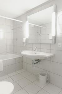 卢塞恩罗斯里宾馆的白色的浴室设有水槽和镜子