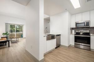 夏洛特CityScape Flat- 3BR Luxury APT in Uptown的厨房配有白色橱柜和炉灶烤箱。
