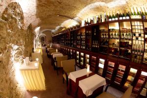 科希策拉缇杜卡酒店的一间设有桌子和酒瓶架的餐厅