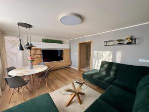 沙莫林Apartmán Olívia的客厅配有绿色沙发和桌子