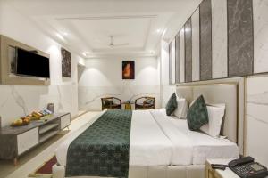 新德里Hotel Transit International- Aerocity Delhi Airport的一间卧室配有一张大床和电视