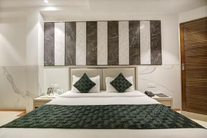 新德里Hotel Transit International- Aerocity Delhi Airport的卧室配有一张带两个枕头的大白色床