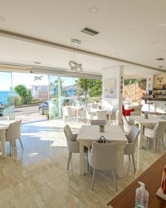 萨兰达Hotel Iliria的一间带桌椅的海景餐厅
